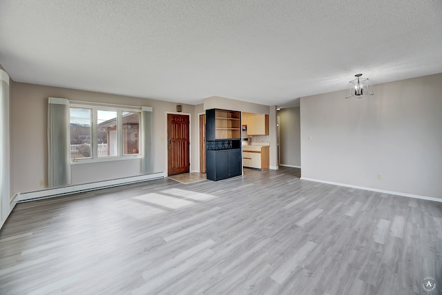 unfurnished living room with light hardwood / wood-style flooring, a textured ceiling, baseboard heating, and a notable chandelier