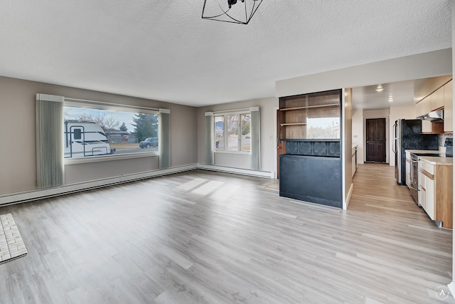 unfurnished living room with light hardwood / wood-style flooring and a textured ceiling