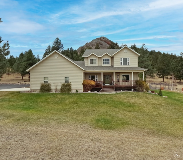 rear view of property with covered porch and a lawn