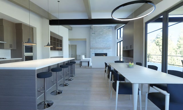 kitchen featuring tasteful backsplash, a stone fireplace, a healthy amount of sunlight, and pendant lighting