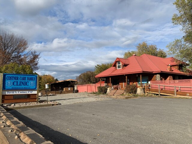 406 W Railroad Ave, Plains, MT 59859 - view of front of house featuring fence, metal roof, and a porch