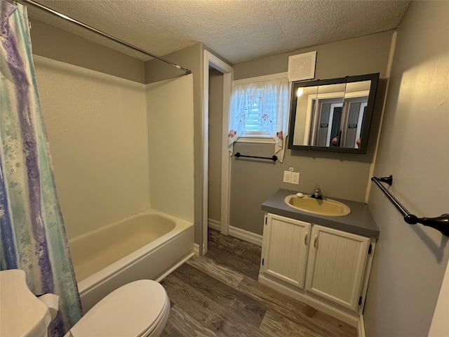 full bathroom with shower / bath combo with shower curtain, toilet, hardwood / wood-style floors, a textured ceiling, and vanity