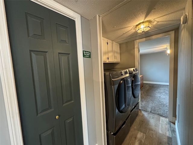 laundry room featuring cabinets, wood-type flooring, a textured ceiling, and washer and dryer