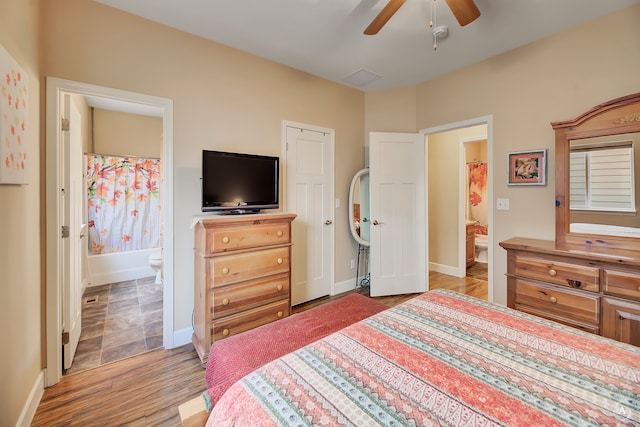 bedroom featuring light hardwood / wood-style floors, ceiling fan, ensuite bath, and a closet