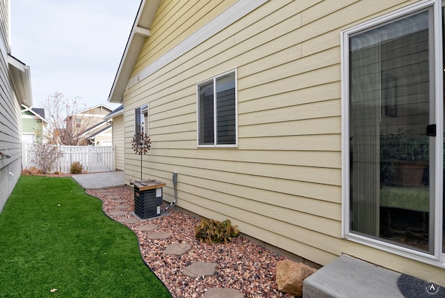 view of property exterior featuring central AC and a yard