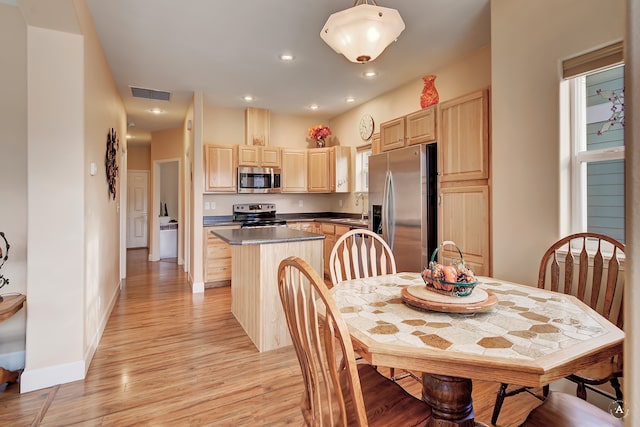 kitchen featuring sink, appliances with stainless steel finishes, light brown cabinets, light hardwood / wood-style flooring, and a center island