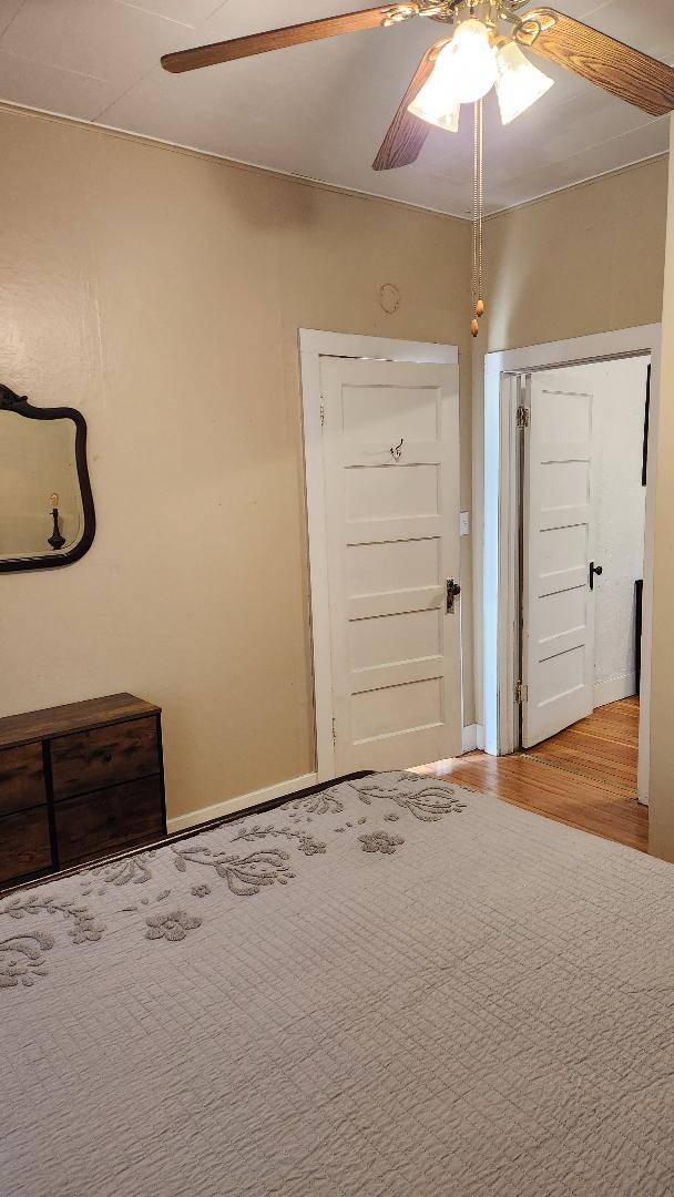 unfurnished bedroom featuring hardwood / wood-style floors and ceiling fan