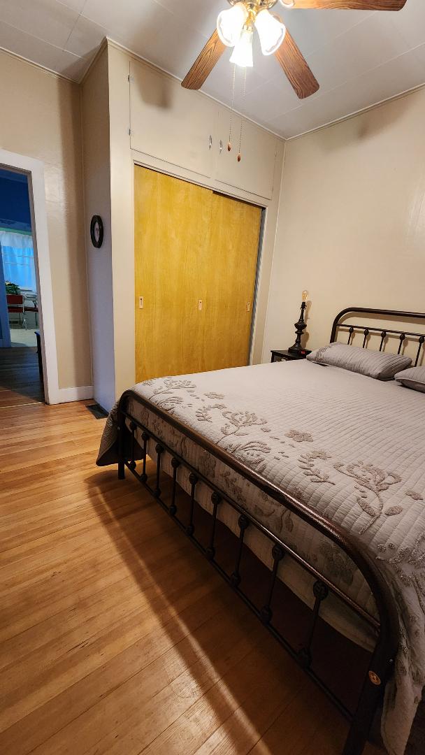 bedroom featuring ceiling fan, light hardwood / wood-style floors, and a closet