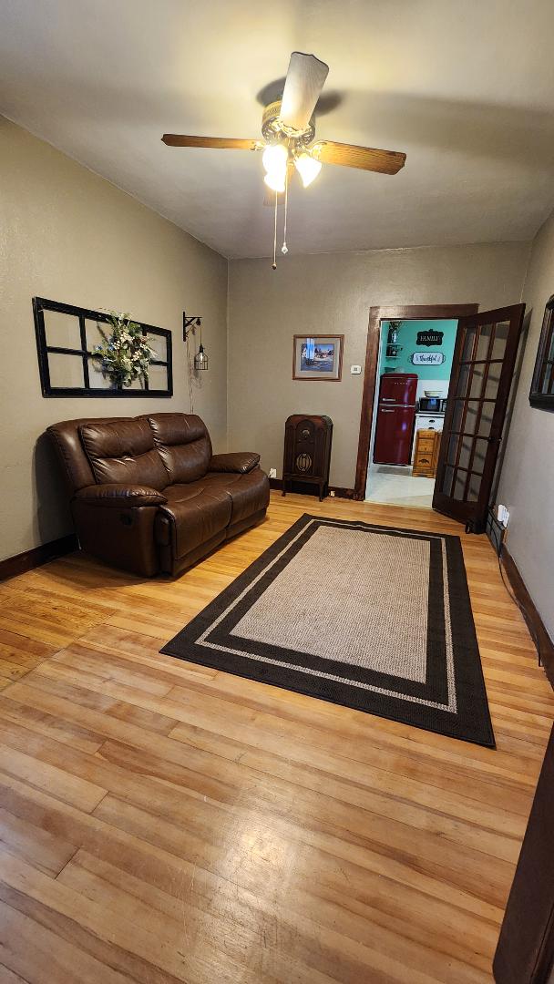 living room with ceiling fan and light hardwood / wood-style floors