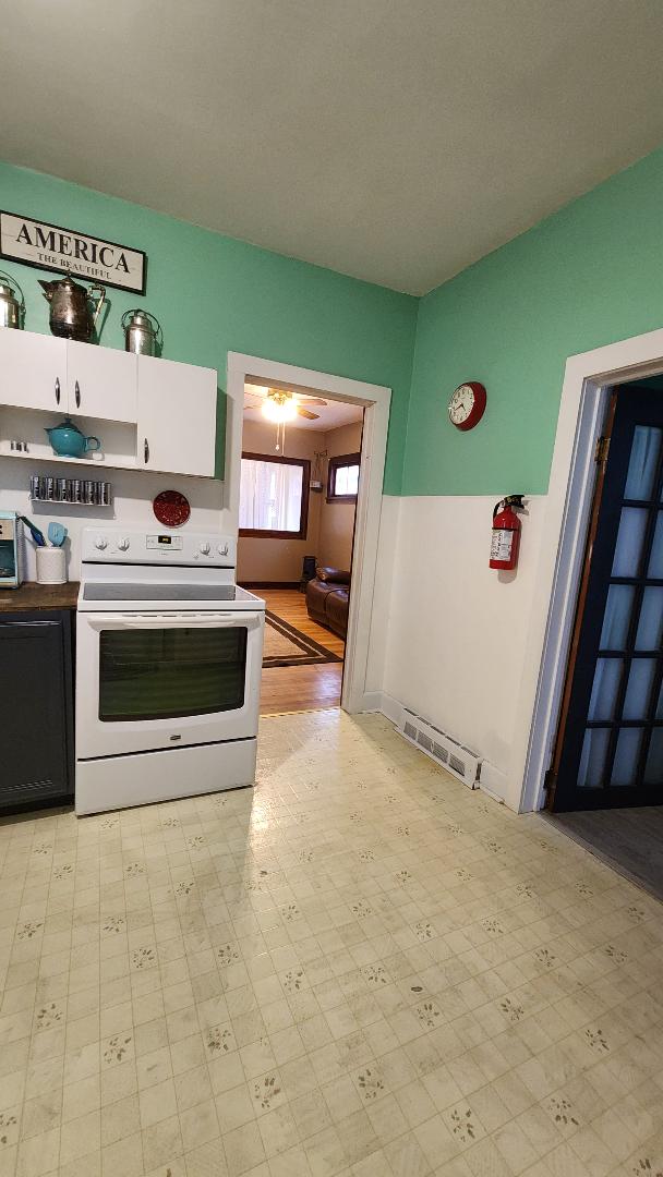 kitchen featuring white cabinetry, white electric stove, and light hardwood / wood-style floors