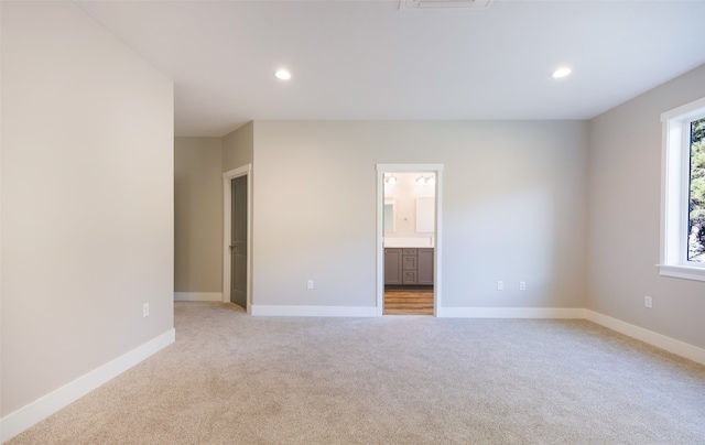 unfurnished room featuring light carpet