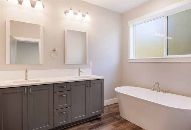 bathroom featuring wood-type flooring, vanity, and a tub