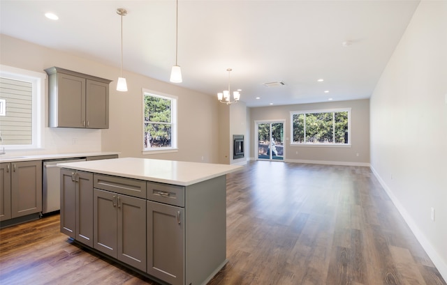 kitchen with tasteful backsplash, stainless steel dishwasher, pendant lighting, a center island, and gray cabinets