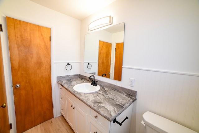 bathroom featuring toilet, vanity, and hardwood / wood-style floors