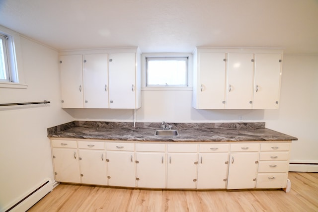 kitchen with a baseboard radiator, sink, white cabinetry, and light hardwood / wood-style flooring