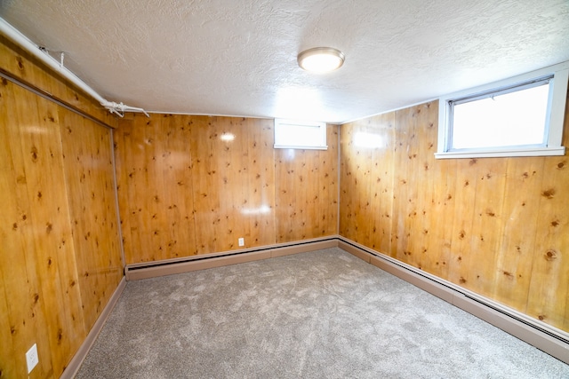 basement featuring carpet floors, a textured ceiling, and wooden walls