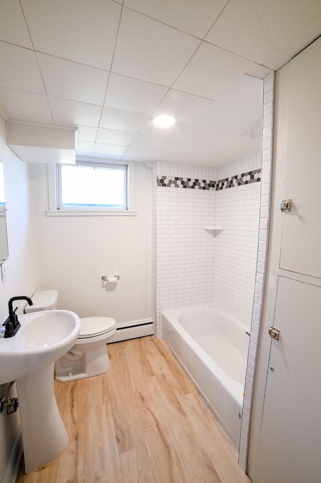 bathroom featuring hardwood / wood-style flooring, a baseboard radiator, toilet, and shower / bath combination