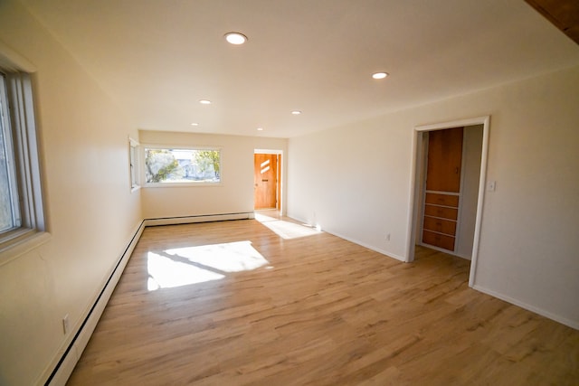 empty room featuring baseboard heating and light wood-type flooring