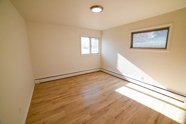 spare room featuring light wood-type flooring and a baseboard heating unit