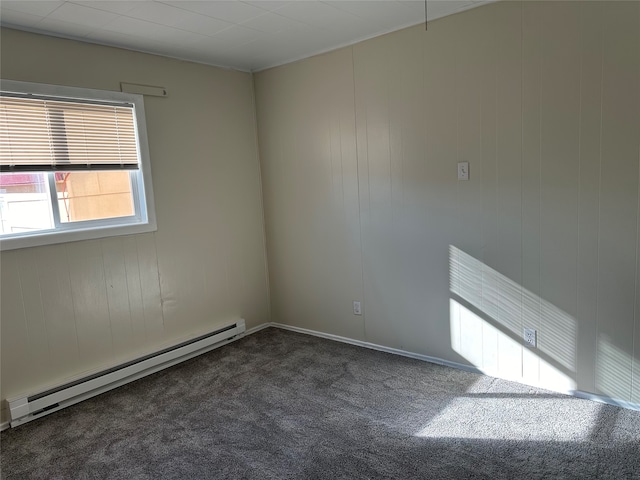 spare room with a baseboard heating unit and dark carpet