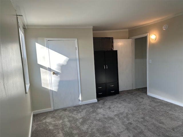 unfurnished bedroom featuring dark colored carpet and crown molding