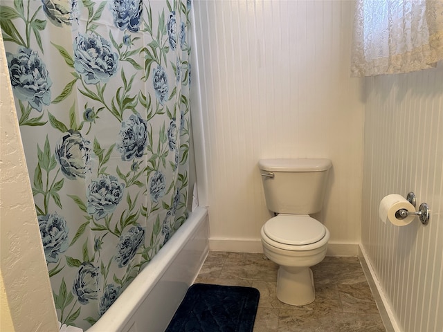 bathroom featuring shower / bath combo with shower curtain and toilet