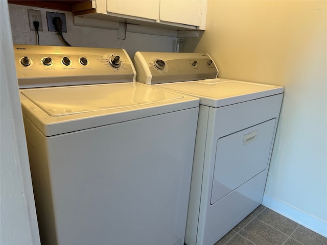 laundry area with dark tile patterned floors, cabinets, and independent washer and dryer