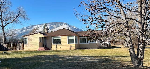 back of property with a yard and a mountain view