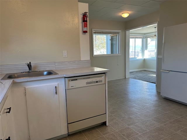 kitchen with white cabinetry, sink, and white appliances