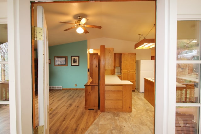 kitchen featuring light hardwood / wood-style floors, ceiling fan, hanging light fixtures, lofted ceiling, and white fridge