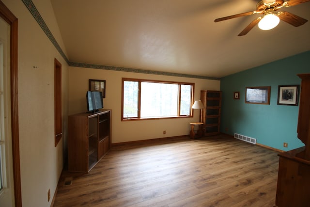 unfurnished living room with vaulted ceiling, hardwood / wood-style flooring, and ceiling fan