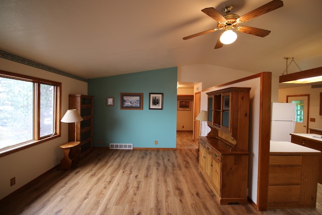 unfurnished living room with light wood-type flooring, lofted ceiling, and ceiling fan