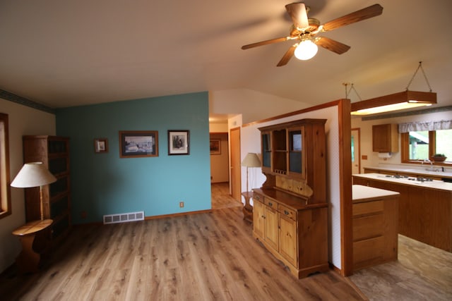 kitchen featuring white gas cooktop, ceiling fan, light wood-type flooring, and vaulted ceiling