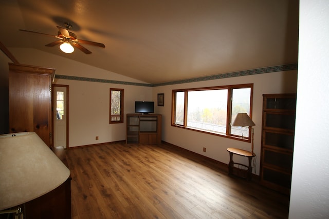 living room with hardwood / wood-style floors, ceiling fan, and vaulted ceiling