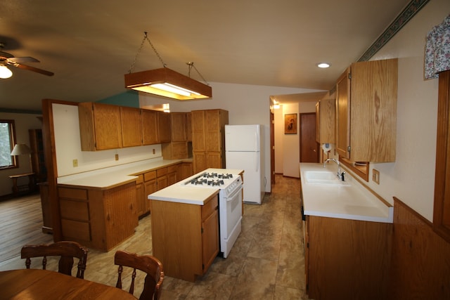 kitchen with hanging light fixtures, sink, white appliances, ceiling fan, and a center island