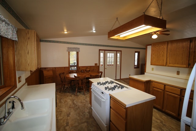 kitchen featuring white range with gas cooktop, sink, kitchen peninsula, lofted ceiling, and ceiling fan