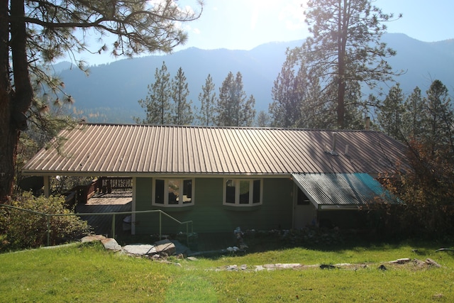 back of house with a yard and a mountain view