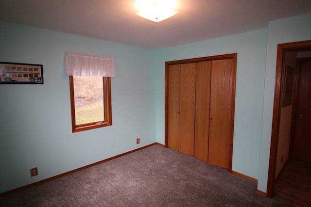 unfurnished bedroom featuring a closet and dark carpet