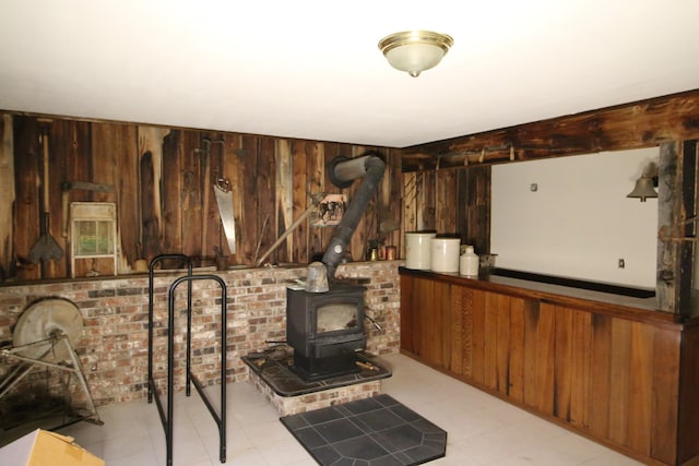 interior space featuring a wood stove and wood walls