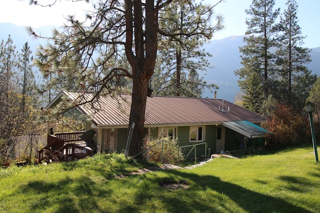 rear view of house featuring a wooden deck and a yard