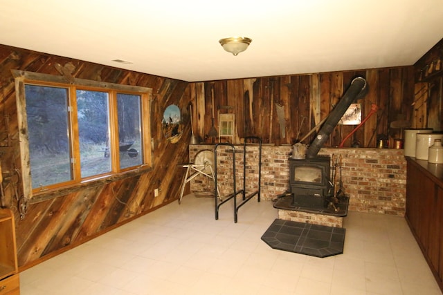 sitting room featuring wooden walls and a wood stove