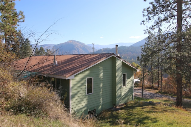 view of side of home with a lawn and a mountain view