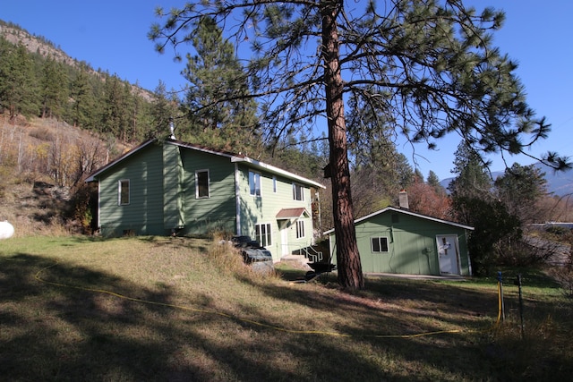 view of side of property with a lawn and a mountain view