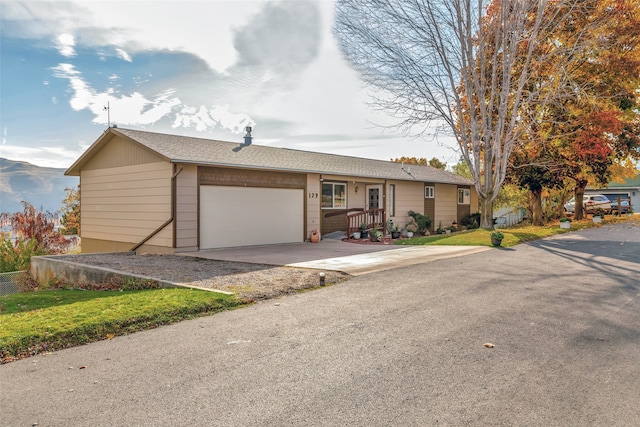 single story home featuring driveway, a garage, and roof with shingles