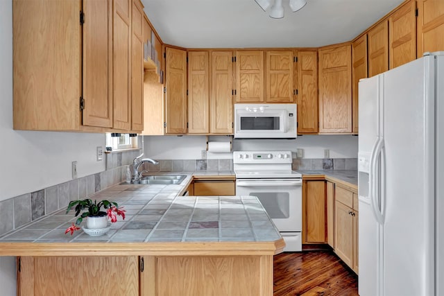 kitchen with white appliances, dark hardwood / wood-style flooring, sink, tile counters, and kitchen peninsula