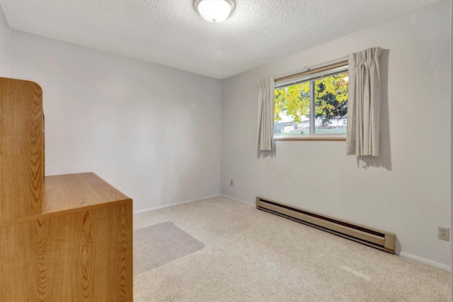 carpeted empty room featuring a textured ceiling, baseboards, and a baseboard radiator