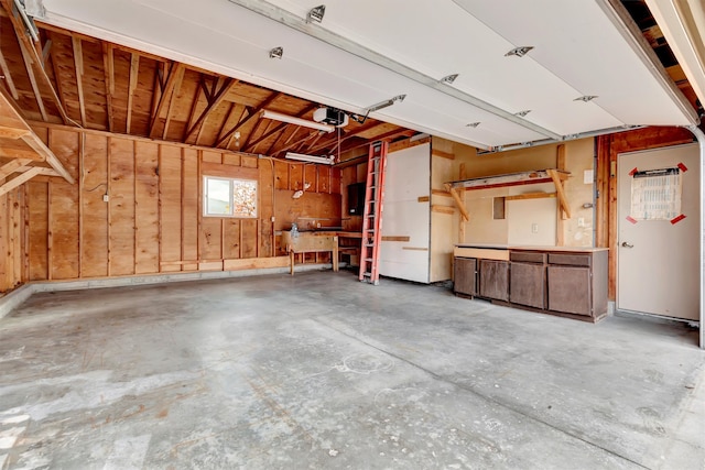 garage featuring a garage door opener and wooden walls