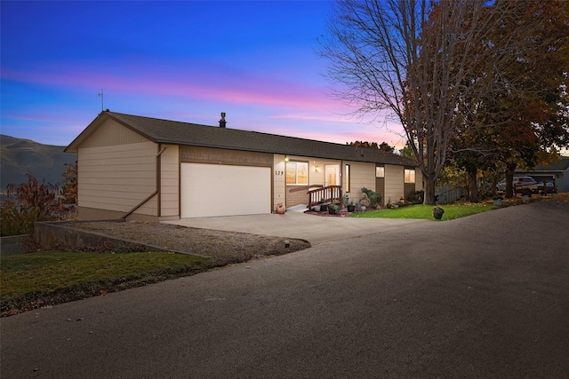 view of front facade featuring a yard, concrete driveway, and a garage