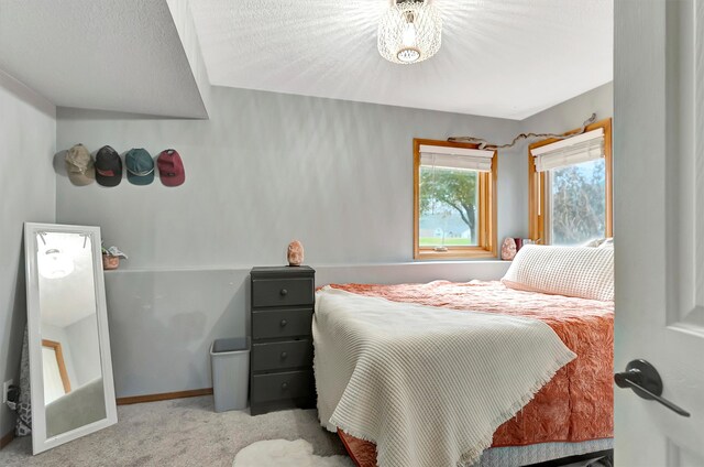 bedroom featuring light colored carpet and a textured ceiling