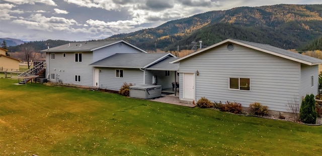 back of house featuring a lawn and a mountain view